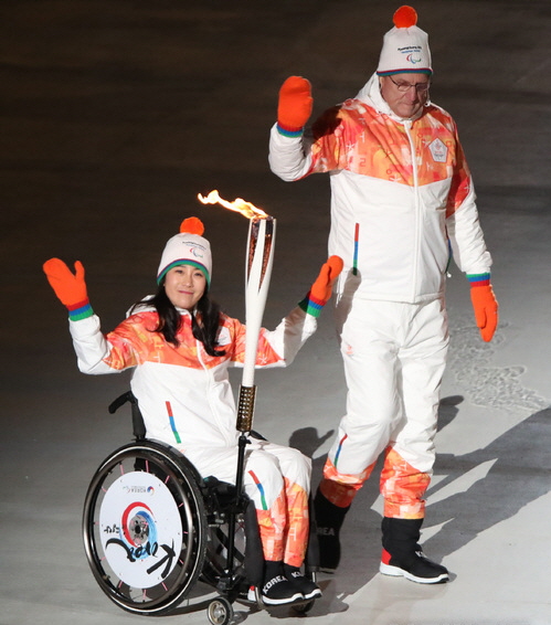 2018 평창동계패럴림픽 개막식이 열린 9일 강원도 평창올림픽스타디움에서 좌식 노르딕스키 좌식 국가대표 서보라미와 카스파 윌츠 코치가 성화를 봉송하고 있다.