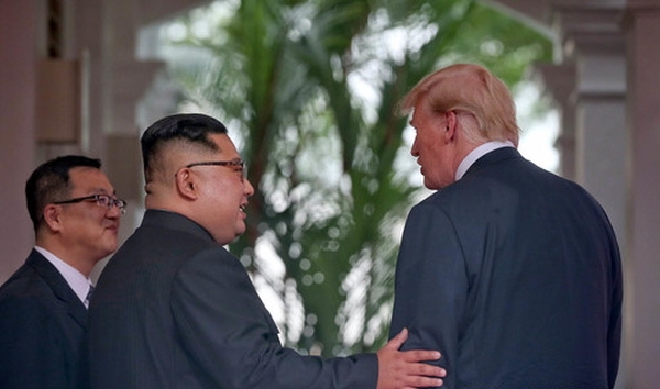 역사적 첫 북미정상회담이 열린 12일 오전 회담장인 카펠라 호텔에서 북한 김정은 위원장과 미국 트럼프 대통령이 회담에 앞서 인사를 나누고 있다. 싱가포르 정보통신부 제공