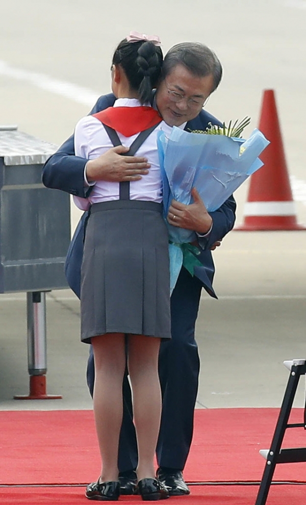 문재인 대통령과 부인 김정숙 여사가 18일 오전 평양 순안공항 도착한 뒤 화동에게 꽃다발을 받은 뒤 포옹하고 있다.