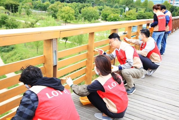 지난 28일 롯데홈쇼핑 샤롯데봉사단들이 서울 영등포구 선유도 공원 내 노후화된 전망대 난간을 도색하고 있다. 롯데홈쇼핑 제공