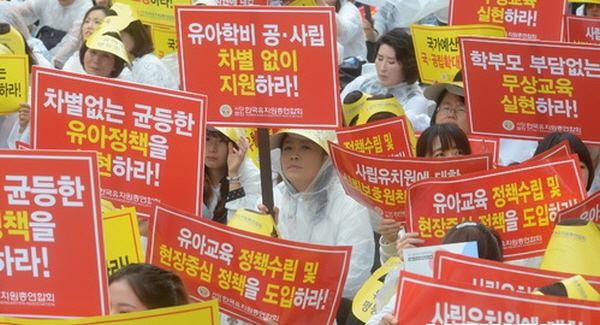 지난해 9월 11일 서울 영등포구 산업은행 앞에서 열린 유아교육 평등권 확보를 위한 전국유치원대회에 참석한 한국유치원총연합회 회원들이 '유아학비 공, 사립 차별없이 지원하라' 손피켓을 들고 구호를 외치고 있다.