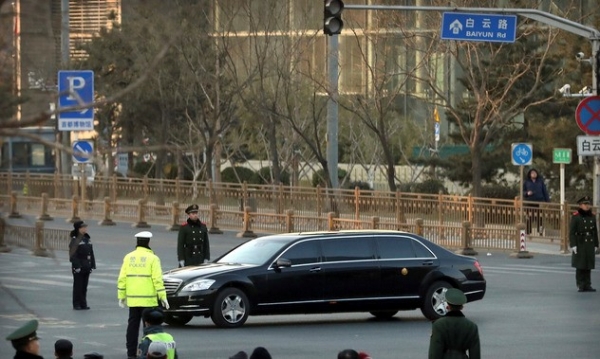 김정은 위원장이 탑승한 것으로 추정되는 검은색 차량이 9일 베이징 시내에서 부동자세를 취하고 있는 무장경찰들 앞을 지나고 있다.