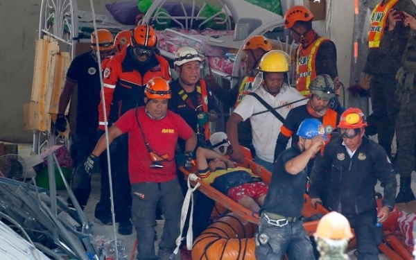 필리핀 팜팡가 주 포라크에서 23일 구호요원들이 전날 발생한 규모 6.1의 지진으로 무너진 건물 잔해더미에서 생존자들을 구해 옮기고 있다.