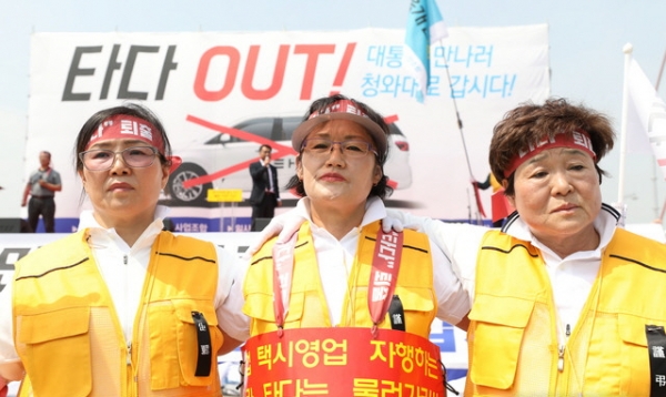 15일 서울 종로구 광화문 광장에서 개인택시운송사업조합 주최로 열린 '타다 퇴출 요구 집회'에서 참석자들이 어깨동무를 하고 있다.