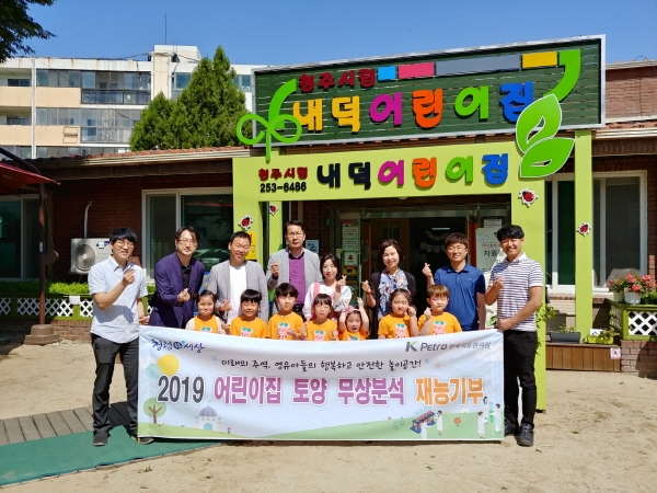 한국석유관리원이 재능기부의 일환으로 어린이들의 안전을 위해 22일 충북 청주 소재 내덕어린이집 놀이터의 토양오염검사를 실시했다. 사진은 석유관리원 석유기술연구소 성광호 시험처장(두번째줄 4번째)과 연구원, 어린이집 관계자 및 어린이들과 함께 기념촬영을 하고 있는 장면.