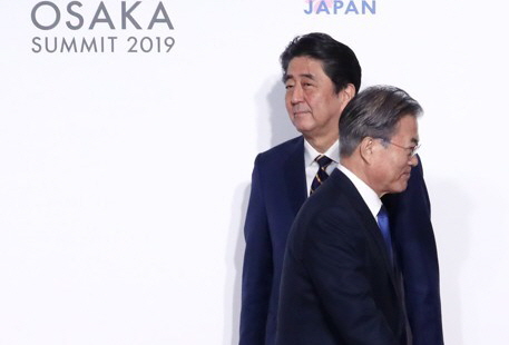 문재인 대통령이 지난달 28일 인텍스 오사카에서 열린 G20 정상회의 공식환영식에서 의장국인 일본 아베 신조 총리와 악수한 뒤 이동하고 있다.