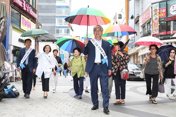 신재섭 원주시의장이 우산을 쓰고  '폭염 시 양산(우산)쓰기 일상화 운동'실천 캠페인을 하고 있다.