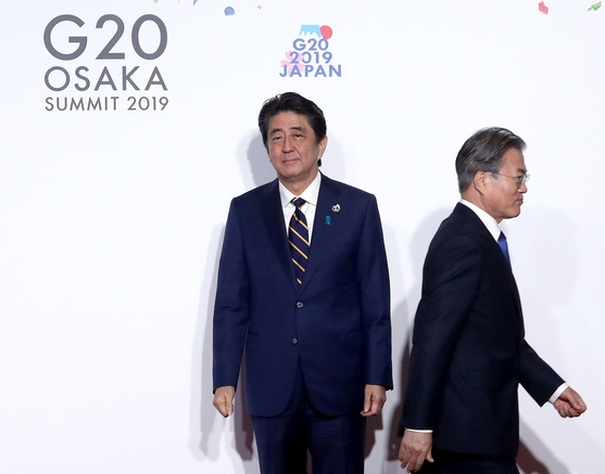 문재인 대통령이 지난달 28일 오전 일본 오사카에서 열린 G20 정상회의 공식환영식에서 의장국인 일본 아베 신조 총리와 악수한 뒤 이동하고 있다.