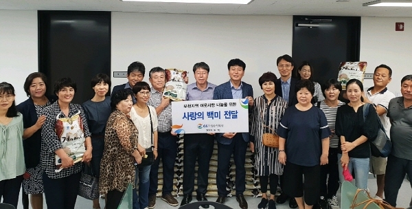 GS파워 사회공헌팀 담당자들이 부천 신흥동 어울마당을 찾아 ‘사랑의 쌀’ 나눔 행사 후 기념촬영을 하고 있다.