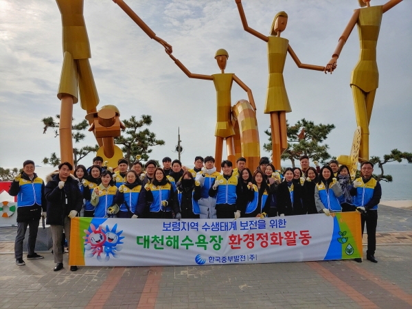 한국중부발전이 대천해수욕장에서 보령지역 수생태계 보전을 위한 환경정화활동을 시행한 후 단체사진을 촬영하고 있다.
