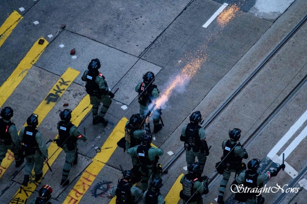 홍콩 경찰이 시위대를 향해 다가서는 사이 한 경찰이 최루탄을 발사하고 있다.(자료:standard.co.uk)