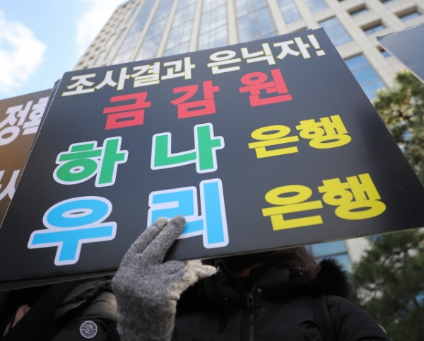 지난달 26일 서울 여의도 금융감독원 앞에서 금리연계형 우리·KEB하나은행 파생결합펀드(DLF) 사태 관련 피해자들이 피켓을 들고 있다.