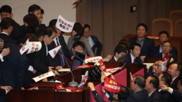지난해 12월 30일, 20대 국회 본회의 중 패스트트랙 법안인 공수처법 통과를 앞두고 자유한국당 의원들이 의장석 앞에서 항의하고 있다. (사진=연합뉴스)