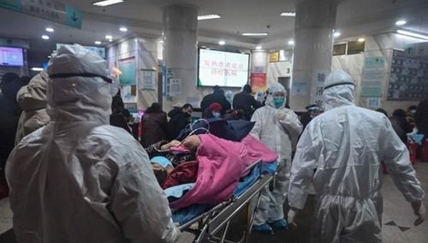 방호복을 입은 의료진들이 25일 중국 우한 적십자병원으로 한 환자를 이송하고 있다.