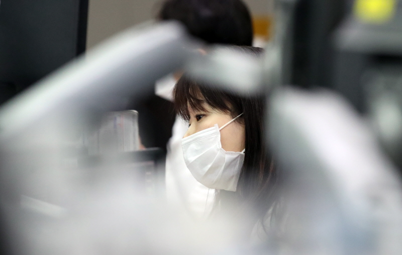 12일 서울 을지로 하나은행 본점 딜링룸에서 한 외환딜러가 마스크를 쓴 채 모니터를 바라보고 있다.