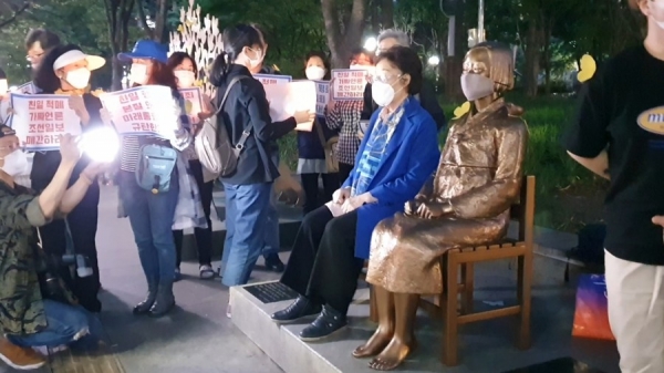 일본군 ‘위안부’ 피해자로 평화인권운동에 앞장서온 이용수(92) 할머니가 27일 대구에서 열린 수요시위에 참석해 평화의 소녀상 옆에 앉아있다. (사진 : 이용수 할머니측)