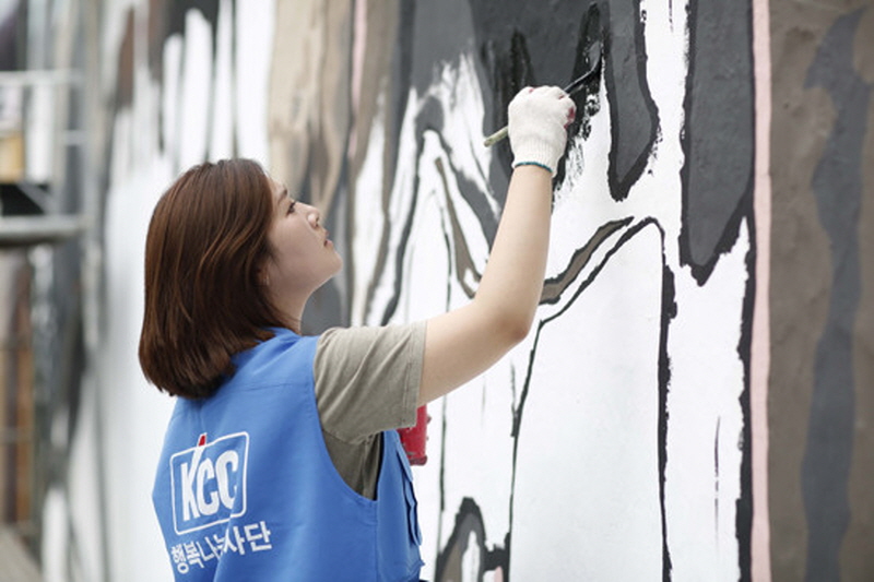 KCC 사내 봉사활동 동호회 직원이 자사의 친환경 페인트를 사용해 벽화를 그리고 있다. KCC 제공