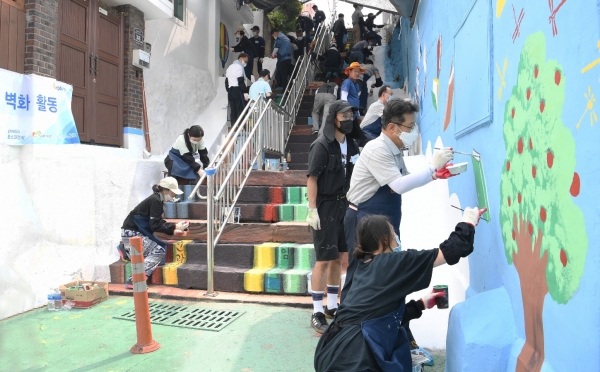 포스코건설 봉사단원들이 9일 배다리마을 계단에서 벽화그리기 봉사활동을 실시하고 있다.