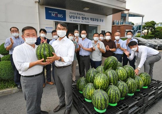 현대모비스가 A/S 부품 우수 협력사 중 한 곳인 우진공업에 감사의 마음을 담아 계절 과일을 선물하고 있다. 사진 왼쪽 정면에 현대모비스 통합구매실 박종원 상무(첫 번째)와 우진공업 류시혁 대표이사. 현대모비스 제공