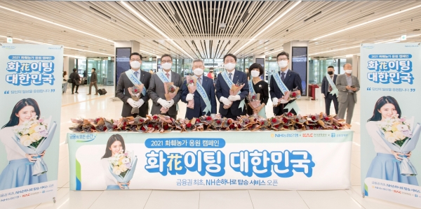 지난 17일 김포공항에서 금융권 최초 농협은행 생체정보 탑승 서비스 개시를 기념해 승객들에게 화훼농가 돕기 꽃나누기 행사를 한 권준학 농협은행장(왼쪽에서 4번째), 손창완 한국공사공사 사장(왼쪽에서 3번째), 김학수 금융결제원장(왼쪽에서 2번째).(제공=NH농협은행)