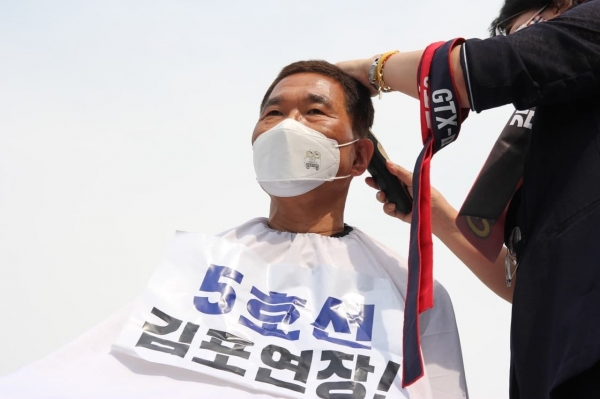 김주영 국회의원(더불어민주당, 경기 김포시갑)이 2일 오후 세종시 국토교통부 앞에서 열린 ‘GTX-D 원안사수! 서울5호선 김포연장을 위한 김포 시민사회단체 결의대회’에서 삭발식을 갖고 있다.(사진=김주영 의원실)