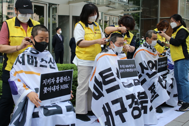 ​​​​​​​홈플러스 여성노동자들이 13일 오후 서울 광화문 디타워 MBK 앞에서 운영사 MBK파트너스의 주요 점포 폐점 매각을 규탄하며 집단삭발을 하고 있다.