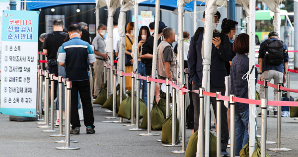 3일 오전 서울 중구 서울역 광장에 설치된 코로나19 선별검사소에 검사를 받으려는 시민들이 줄지어 서 있다. 연합뉴스