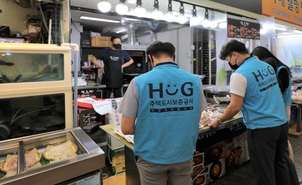 HUG 직원들이 시장을 방문해 구입할 물품을 고르는 모습 (사진=HUG)