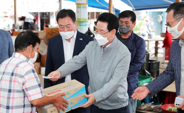 김영록 전남지사가 17일 무안 일로시장 상점에서 전남행복지역화폐인 무안사랑상품권으로 물건을 구입하고 있다.(사진=전남도 제공)