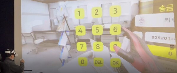 VR헤드마운트 장비를 머리에 쓰고 가상 공간에서 은행업무를 보는 KB국민은행 직원의 시연 장면(제공=KB국민은행)