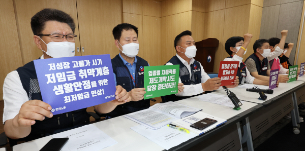 최저임금위원회 회의에 참석하는 근로자 위원들이 지난달 21일 오후 세종시 정부세종청사에서 열리는 제5차 전원회의에 앞서 2023년 적용 최저임금 노동계 요구안 발표 기자회견을 하며 구호를 외치고 있다. 연합뉴스