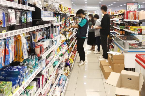 편의점 업주들이 최저임금 인상에 부담을 느껴 본사를 향해 심야에 물건값을 더 받는 심야할증제 도입을 촉구하기로 했다. 심야할증제 외에 주휴수당을 지급하지 않기 위한 근무시간 조정 움직임도 보인다.사진은 6일 서울 시내 한 편의점에서 업무를 보는 직원. 연합뉴스