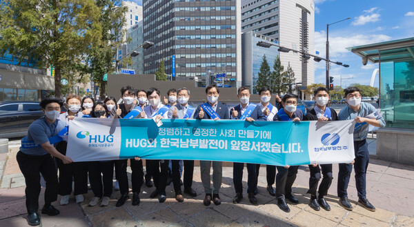 김명수 상임감사위원(오른쪽 여섯 번째)이 남부발전, 주택도시보증공사 직원들과 함께 부산 도시철도 중앙역 일원에서 동행 캠페인을 마치고 기념촬영을 하고 있다.