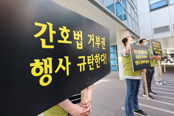 고려대 안암병원 간호사와 전국보건의료산업노동조합 조합원들이 16일 오후 조규홍 보건복지부 장관이 현장 방문한 서울 고려대학교 안암병원에서 윤석열 대통령의 간호법 제정안에 대한 법률안 거부권 행사를 규탄하며 손팻말을 들고 있다./사진=연합뉴스