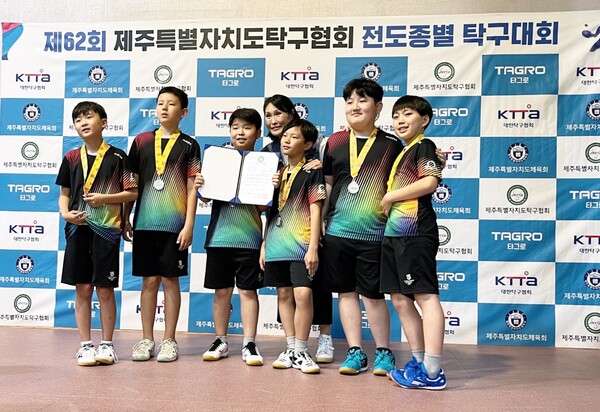 제62회 제주도 탁구대회 초등학생부 남자 개인 단·복식과 단체전에서 금메달 2, 은메달 1, 동메달 1를 차지한 SJA Juju 탁구 동아리 학생들의 수상 후 기념촬영. (왼쪽부터 유채율, 필릭스, 유하율, 김혜진 코치, 안현빈, 김규민, 염규서) (사진 제주 탁구협회)