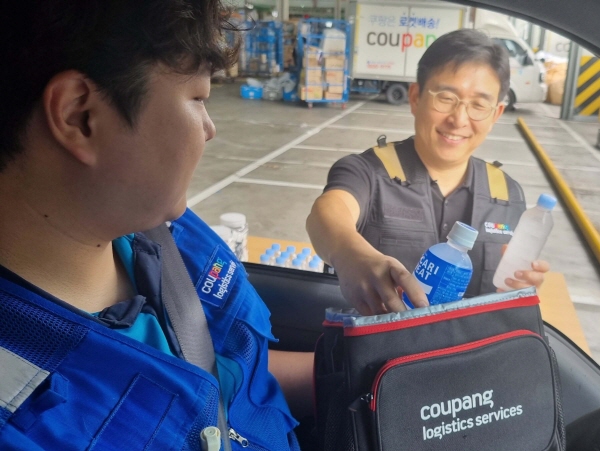 쿠팡로지스틱스서비스 홍용준 경영지원부문 대표이사가 서울 송파캠프에서 배송 나가는 쿠팡친구에게 이온음료와 생수를 전달하고 있다. 쿠팡 제공