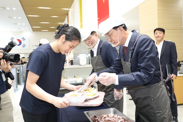 노동진 수협중앙회장이 배드민턴 세계 1위 안세영 선수에게 수산물 특식을 배식하는 모습(제공=수협)