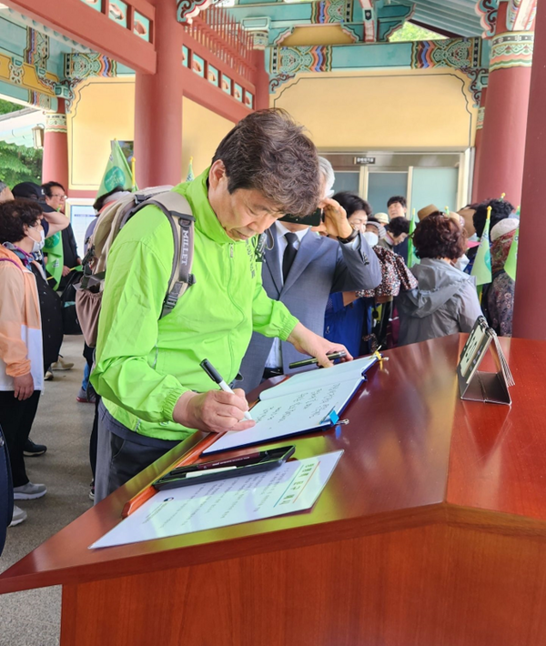 신계륜 전 의원이 광주 망월동 5.18 국립 민주묘지를 참배하기 위해 방명록에 서명하고 있다.