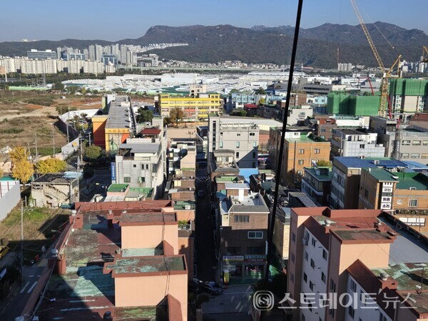 경기도 광명 소하동에 들어설 유승종합건설의 '광명 유승한내들 라포레'는 다세대와 다주택 등 노후 주택이 밀집된 소하동에 자리한다. 사진의 전면의 노란색 건물은 개교 97년의 소하서면초등학교. 그 뒷편에 기아오토랜드가 자리한다.오른쪽은 유승한내들보다 분양가가 17% 저렴한 신원아침의도시 건설현장.(사진 : 김태현 선임기자)