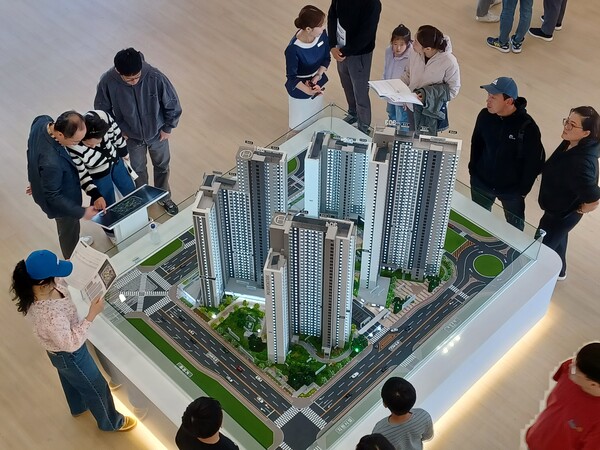 예비청약자들이 원건설이 청주테크노폴리스 S3블록에 공급하는 '힐데스하임 더원'의 견본주택 내부에 설치된 모형을 둘러보고 있다. ⓒ스트레이트뉴스 (사진: 김태현 선임기자)