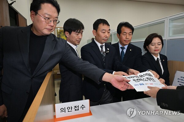 12일 오전 야 6당 의원들이 ‘윤석열 대통령 탄핵 소추안’을 서울 여의도 국회 의안과에 제출하고 있다. 연합뉴스