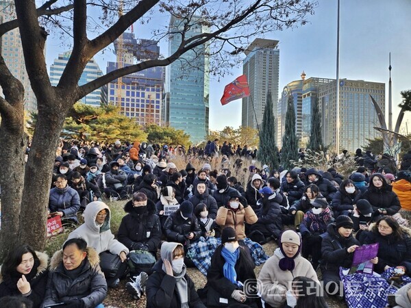 국회 본회의가  14일 오후 4시경 윤석열 대통령의 탄핵 소추안 통과를 기다리며  여의도 광장 녹지에서 '윤석열 타도'와 '국민의힘 해체'를 외치며 질서정연하게 농성 중인 시민. (스트레이트뉴스 양용은 기자)