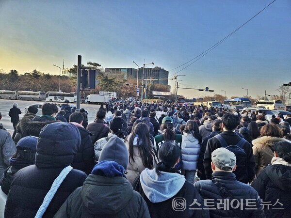국회 본회의가  14일 오후 3시 넘어 영하의 한파를 뜷고 윤석열 대통령의 탄핵을 촉구하기 위해 마포대교 등을 건너 온 탄핵집회 참여 시민이 여의도광장을 향해 신호등을 건너고 있다. (스트레이트뉴스 양용은 기자)