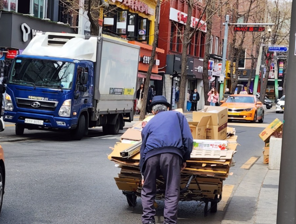 주운 폐지를 모아 담은 손수레를 끄는 노인. 연합뉴스 제공.
