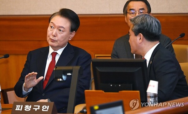 윤석열 대통령이 탄핵심판 6차 변론이 열린 6일 서울 종로구 헌법재판소 대심판정에서 변호인단과 대화하고 있다. 연합뉴스