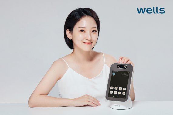 교원웰스의 '웰스 스마트 미러'는 인공지능(AI) 피부 진단 솔루션을 적용한 지능형 거울이다. 피부 진단 기능을 실행한 후 안내에 따라 거울을 보고 사진을 찍으면 AI가 빅데이터 분석을 통해 얼굴 전체의 피부 상태를 모공, 주름, 트러블을 기준으로 진단하고, 각 부위별 측정 결과를 한 화면에 표시해 준다. 교원그룹 제공