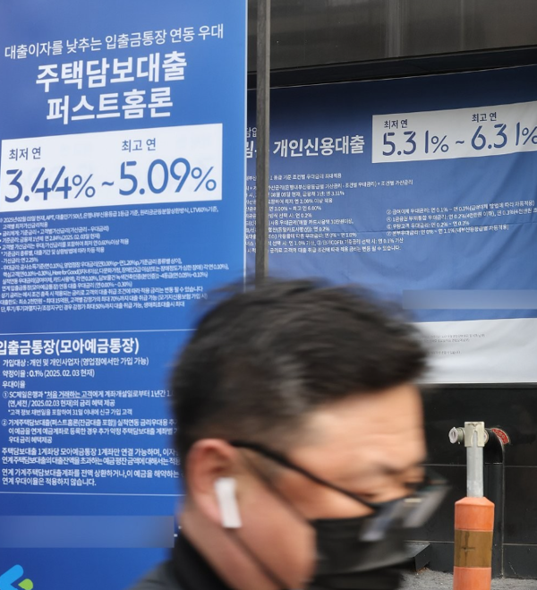                   한 은행의 주담대 광고판 앞을 지나는 행인. 연합뉴스 제공.