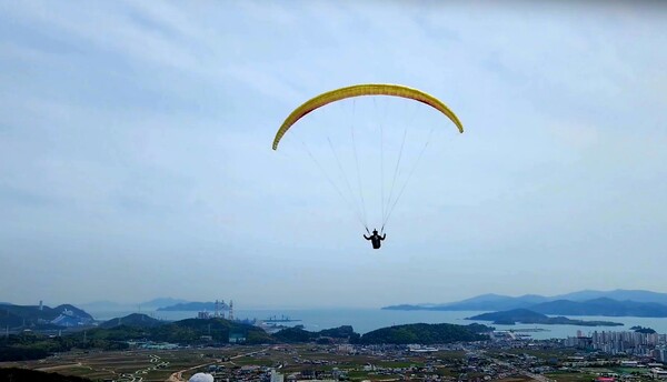 와룡산 활공장에서 패러글라이딩 선수가 사천의 푸른 하늘을 날고 있다. 사천시 제공