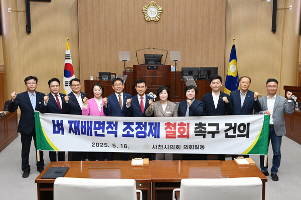 사천시의회가 지난 16일 열린 임시회에서 '벼 재배면적 조정제 철회 촉구 건의안'을 만장일치로 원안 가결하고 난 뒤 기념촬영을 하고 있다. 사천시의회 제공