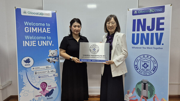 인제대 허경혜 국제교류처장(오른쪽)과 월드 코리아 미얀마 줄리아나 로이 셍 대표(왼쪽)가 미얀마 현지에 설치된 인제대 지정 한국어교육센터 현판을 함께 들고 기념촬영을 하고 있다.     인제대 제공